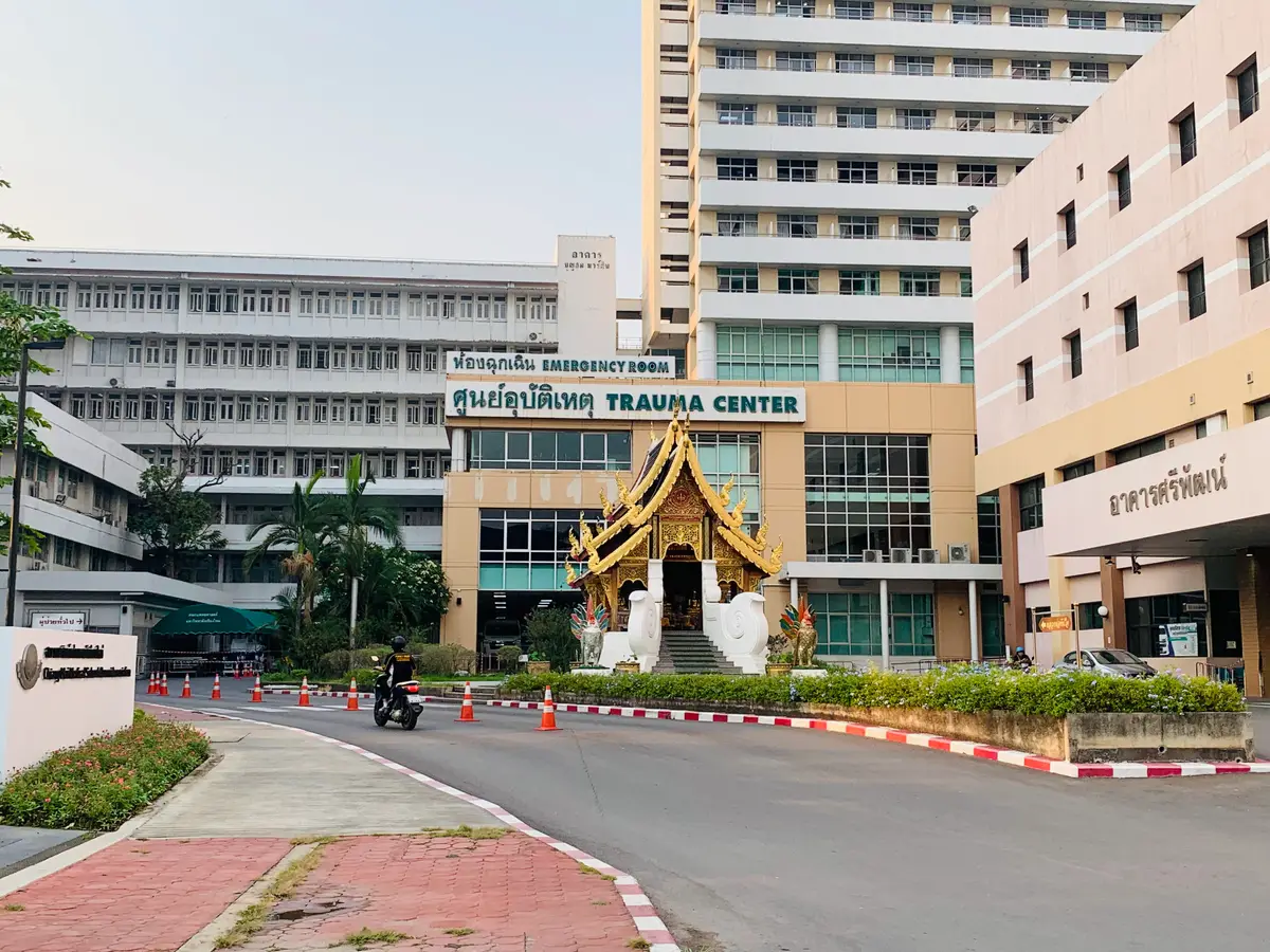 Trauma Center building with a gold Lanna-style pavilion in front and a road with red and white kerbs.