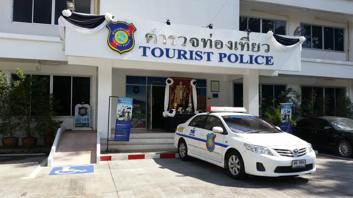 Tourist Police sign above an entrance with a white patrol car parked in front.