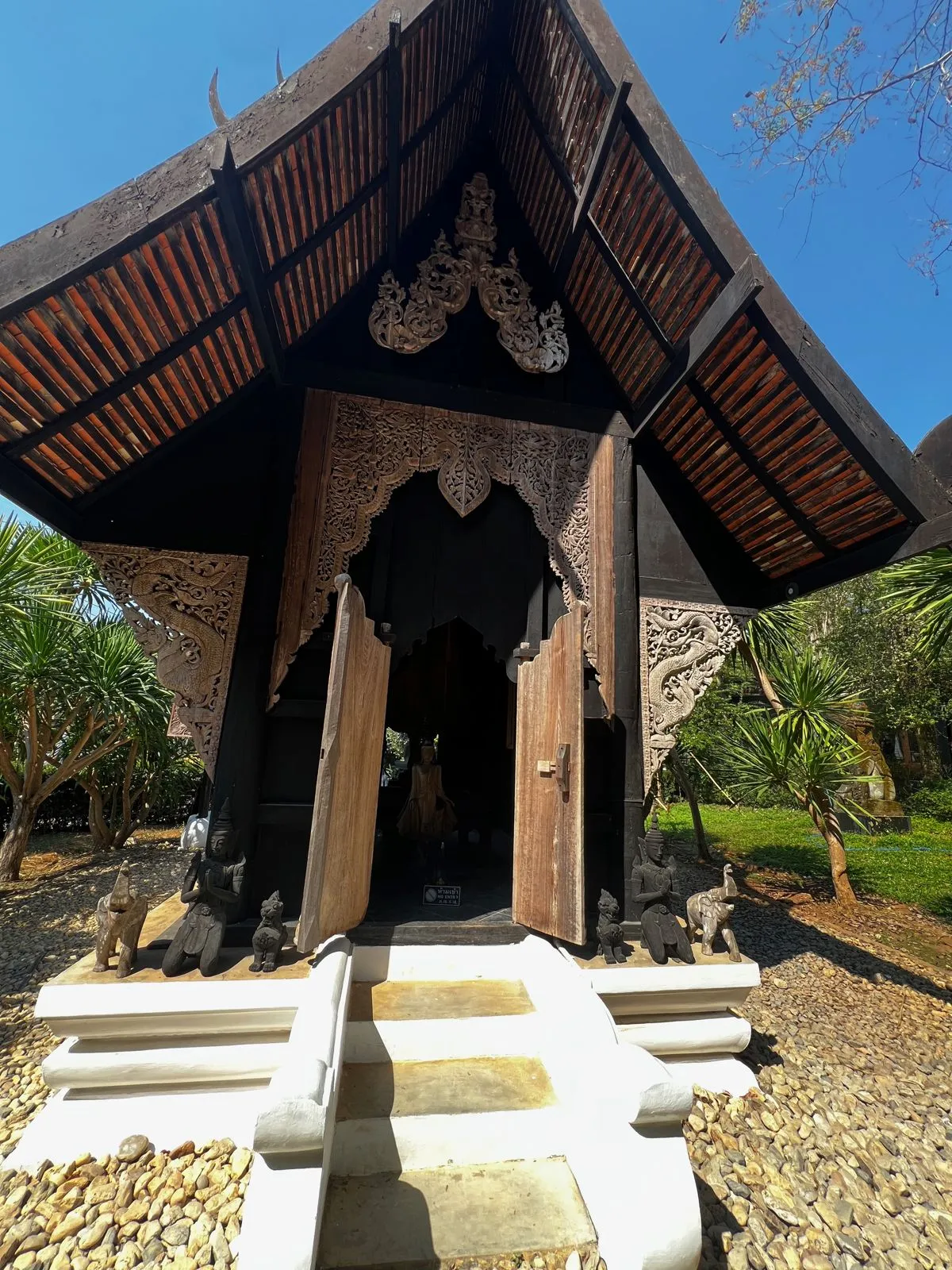 Carved wooden doorway with a stepped stone entrance under a tiled roof