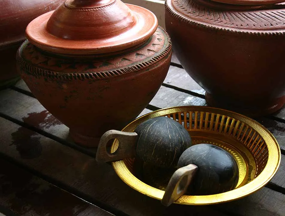 Clay water jars with a gold bowl at a temple near Chiang Mai.