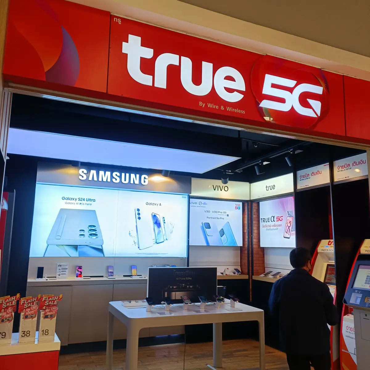 Red True shop front with the True 5G sign above shelves of phones.