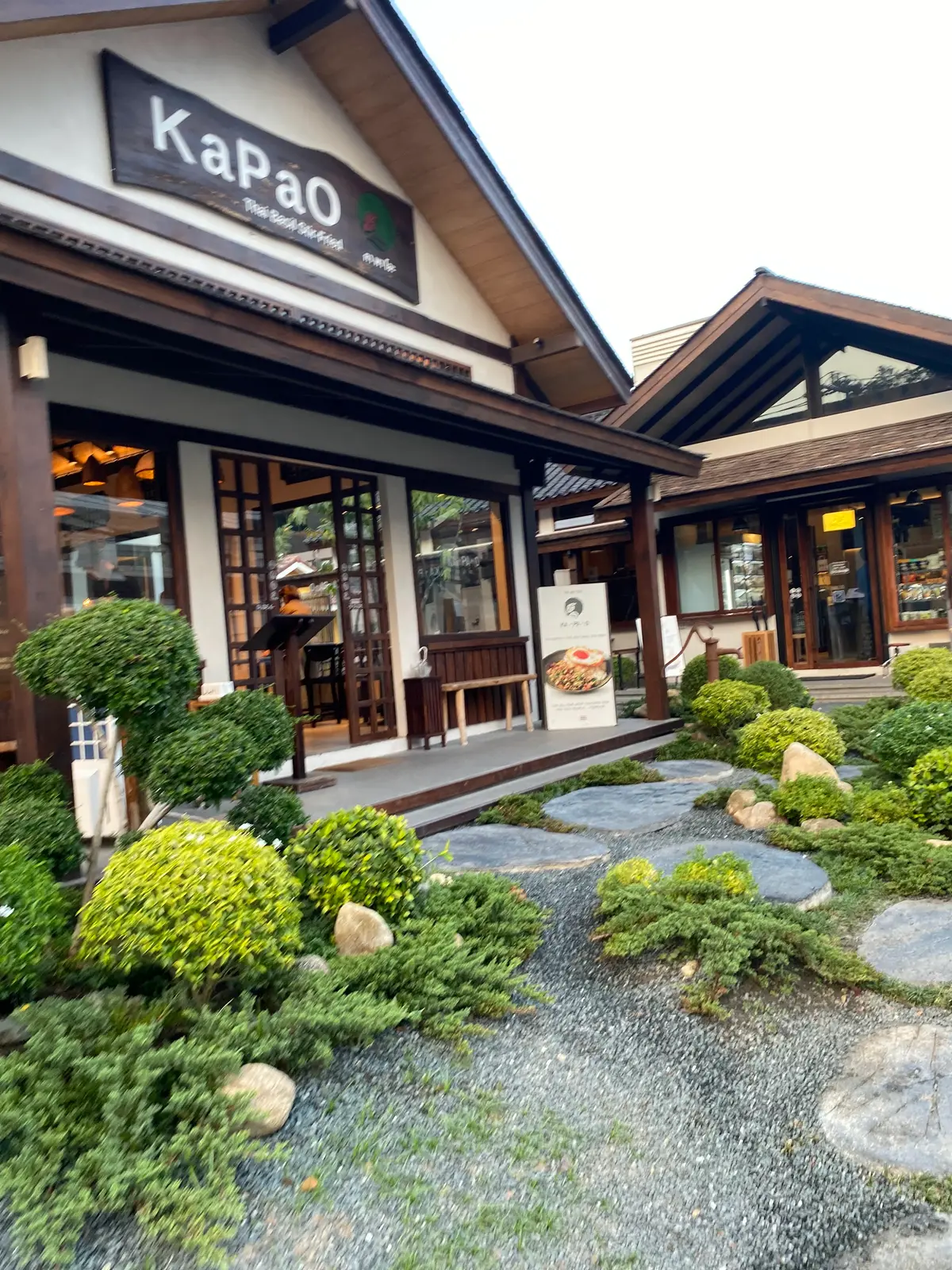 Timber-fronted restaurant with a small stone garden and clipped shrubs