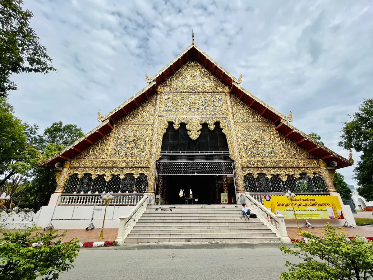 Hall with a gold-decorated gable above wide steps, seen from the front