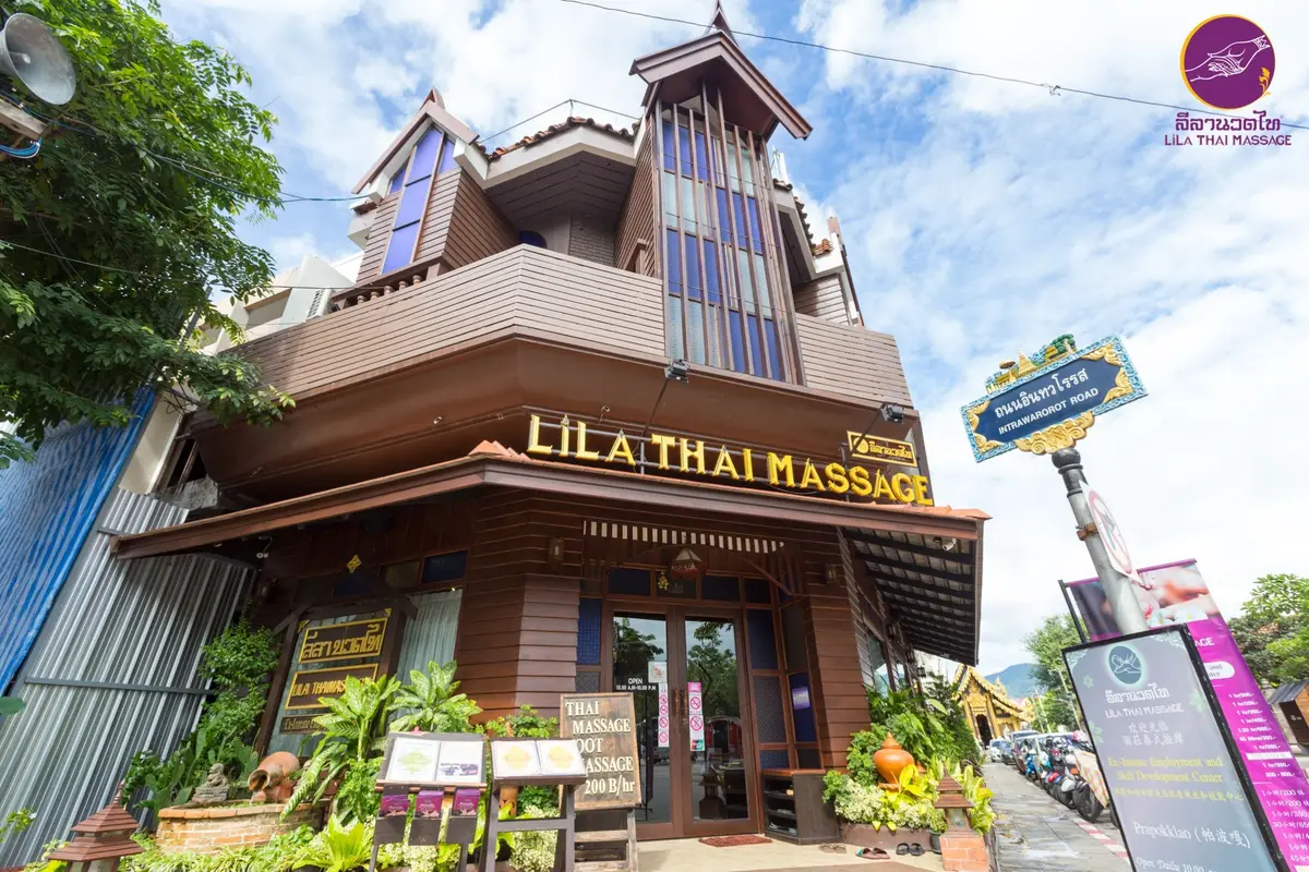 A dark wooden three-storey shopfront with the sign Lila Thai Massage above the entrance.