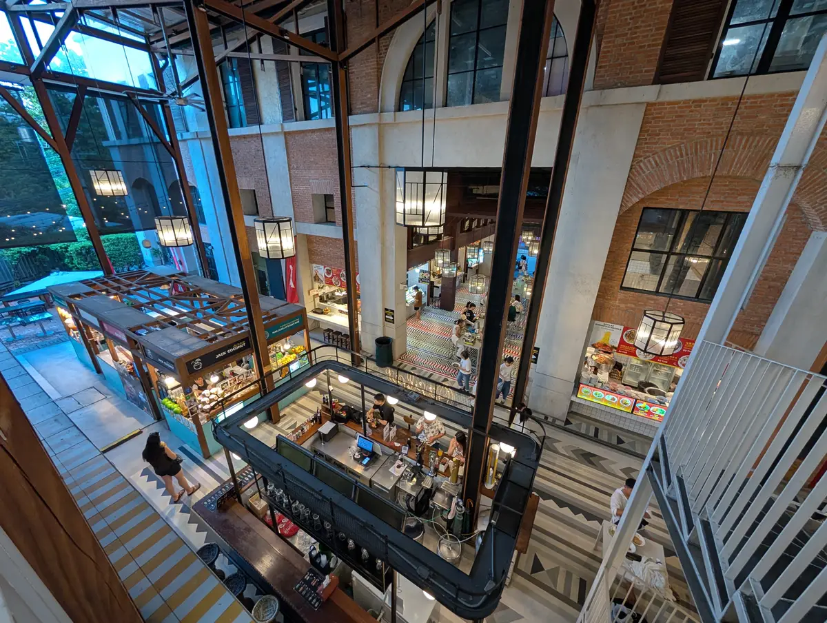 Looking down into an open atrium of shops and cafes in a brick and glass building